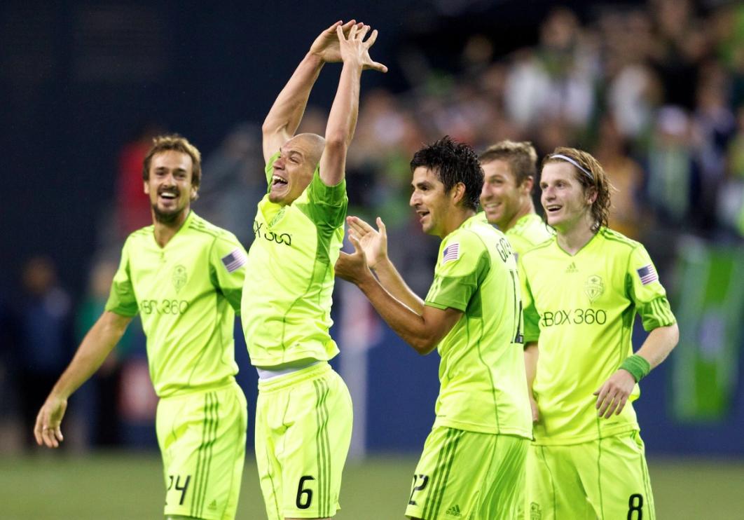 Five players in Seattle Sounders FC uniforms cheering