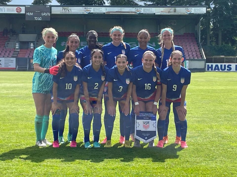 the starting 11 for the u15 us wynt in blue kits and shorts smiling at center field