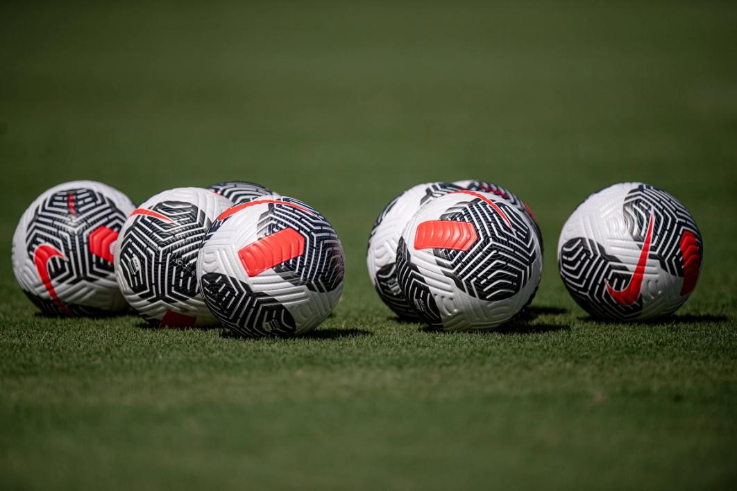 Seven soccer balls on a field