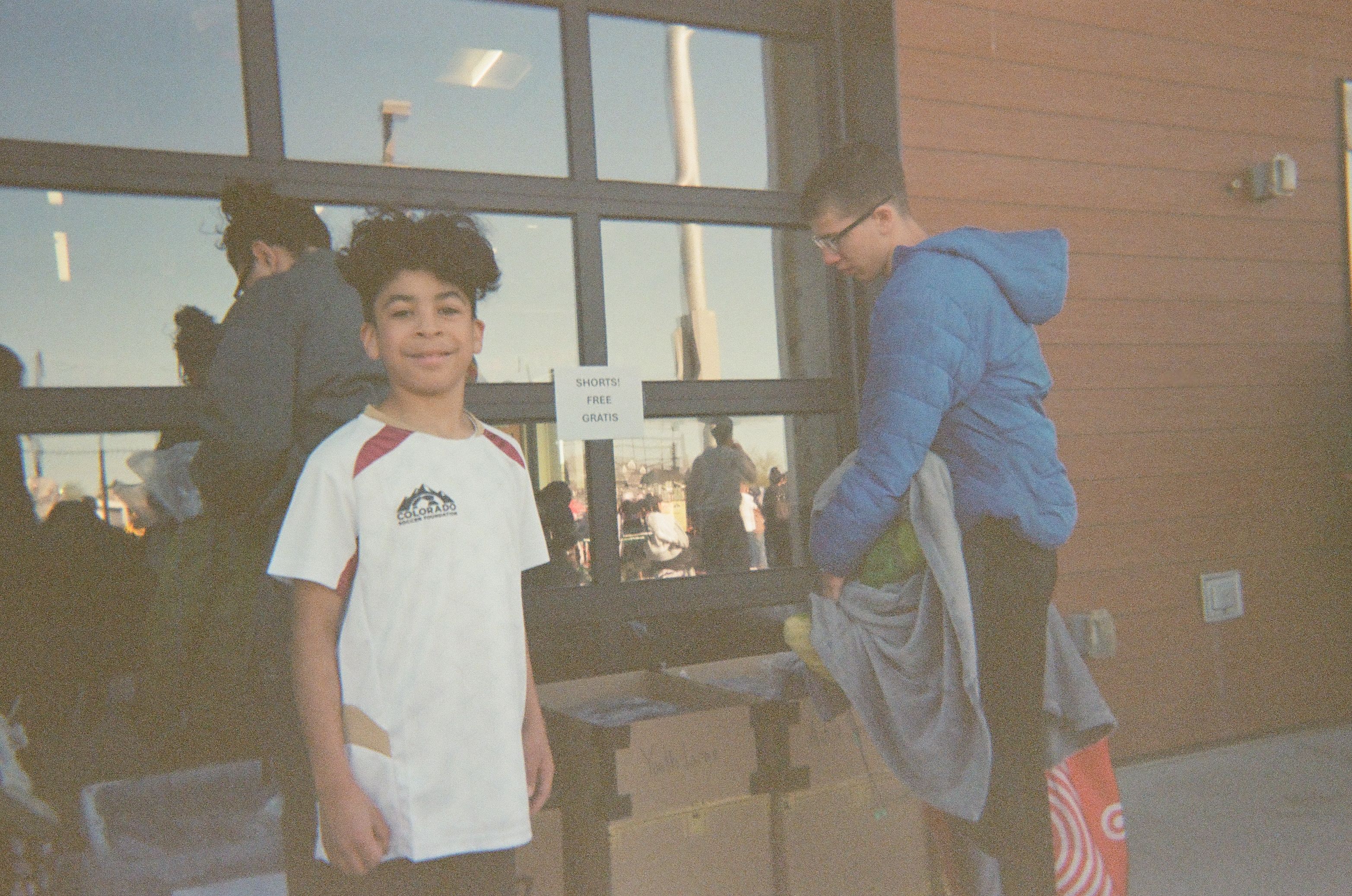 Young soccer player standing outside Soccer City during a Colorado Soccer Foundation community event.