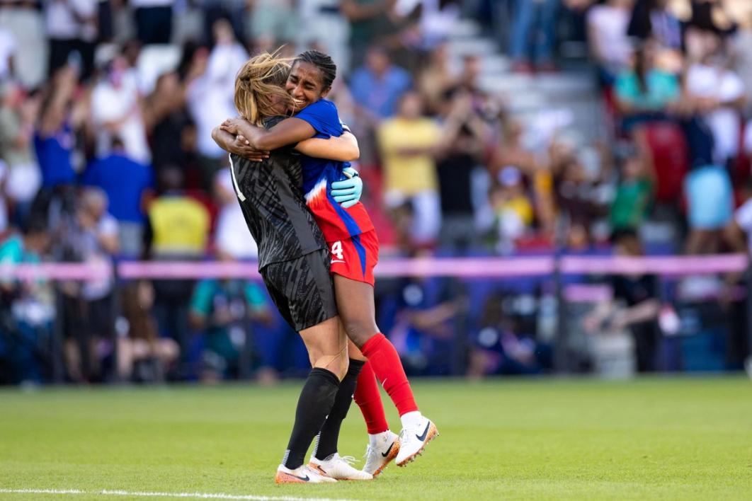 Naomi Girma and Alyssa Naeher share a hug on the field