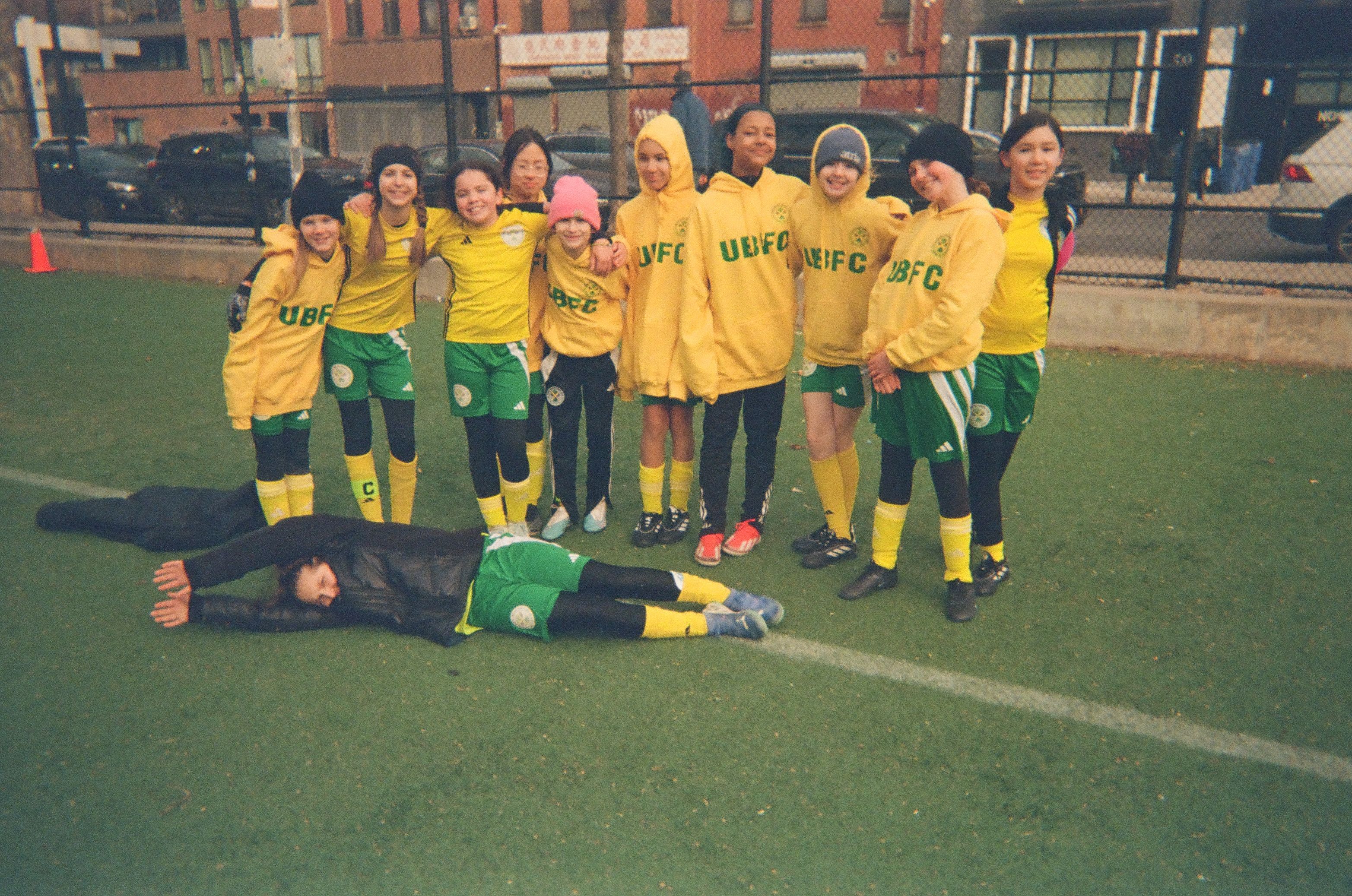 A group of girls posing for a team photo after soccer practice.