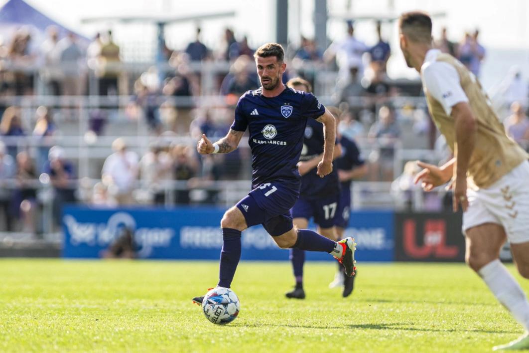 McCabe running with a ball during a match