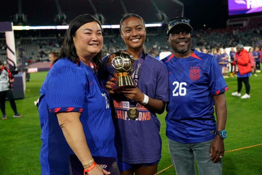 Jaedyn Shaw poses with her parents and the Golden Ball trophy after the 2024 Concacaf W Gold Cup