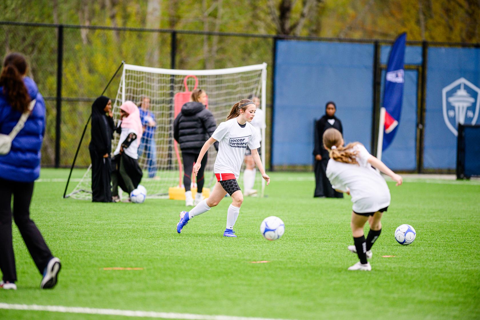 Two girls participating in a soccer training session.