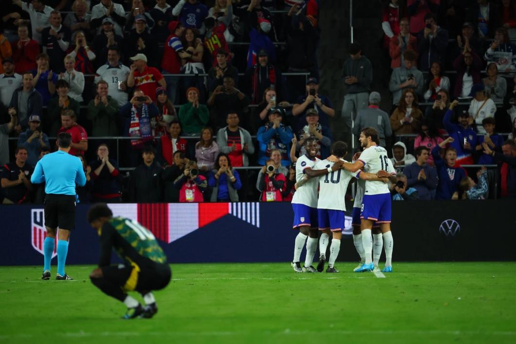 Players for the USMNT celebrate a goal against Jamaica