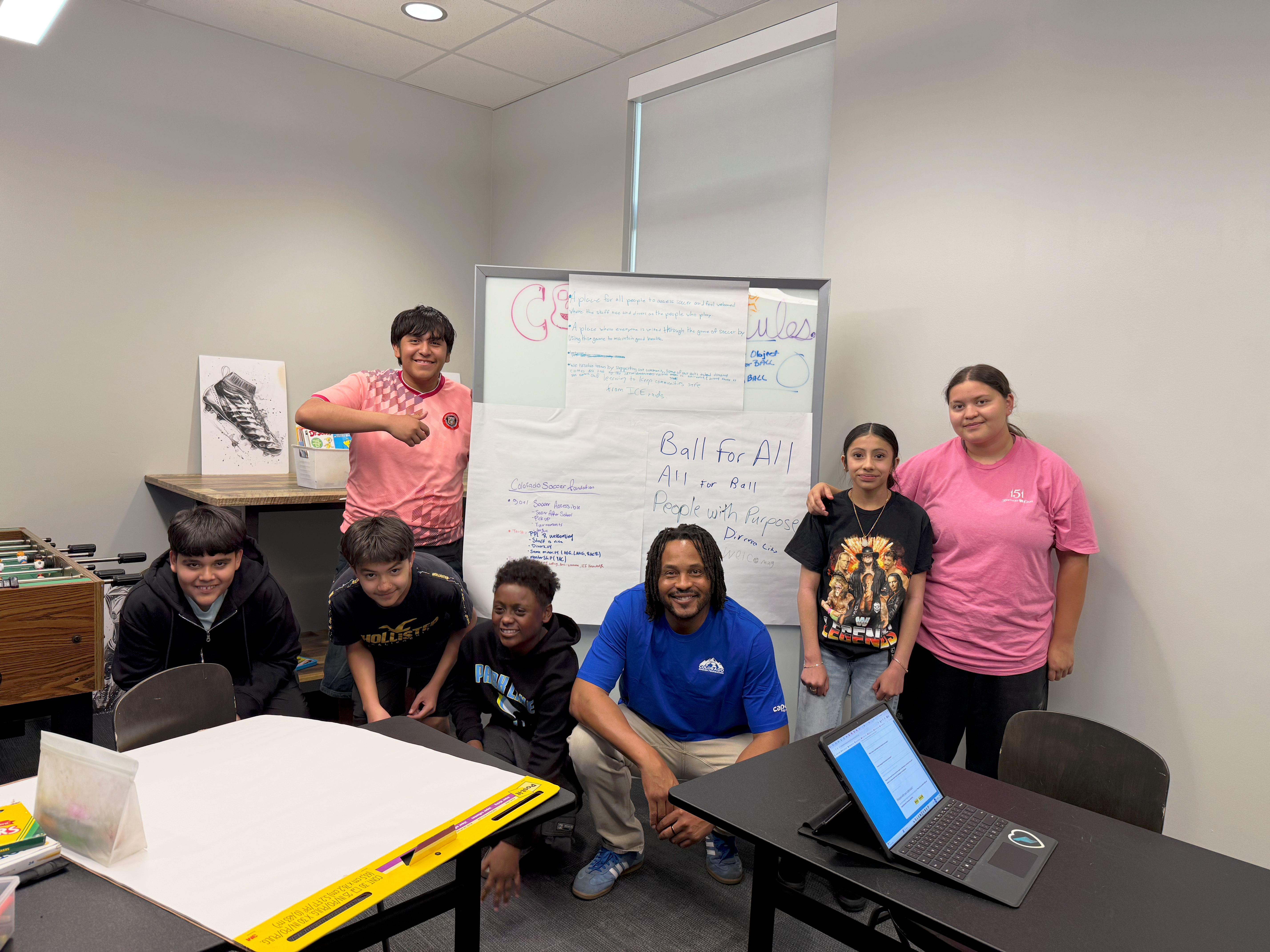 Group of young people gathered in a classroom space during a youth leadership and community discussion session.
