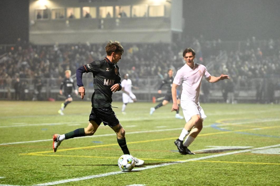 A Portland player dribbles the ball up the field