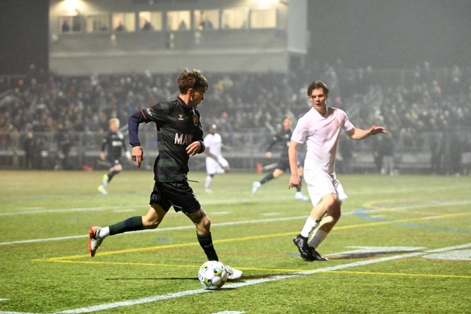 A Portland player dribbles the ball up the field