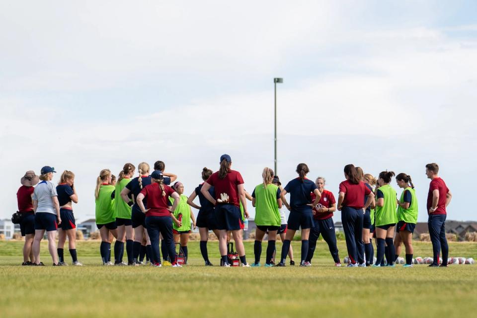 The Deaf WNT meeting with coaches on the field during a training session