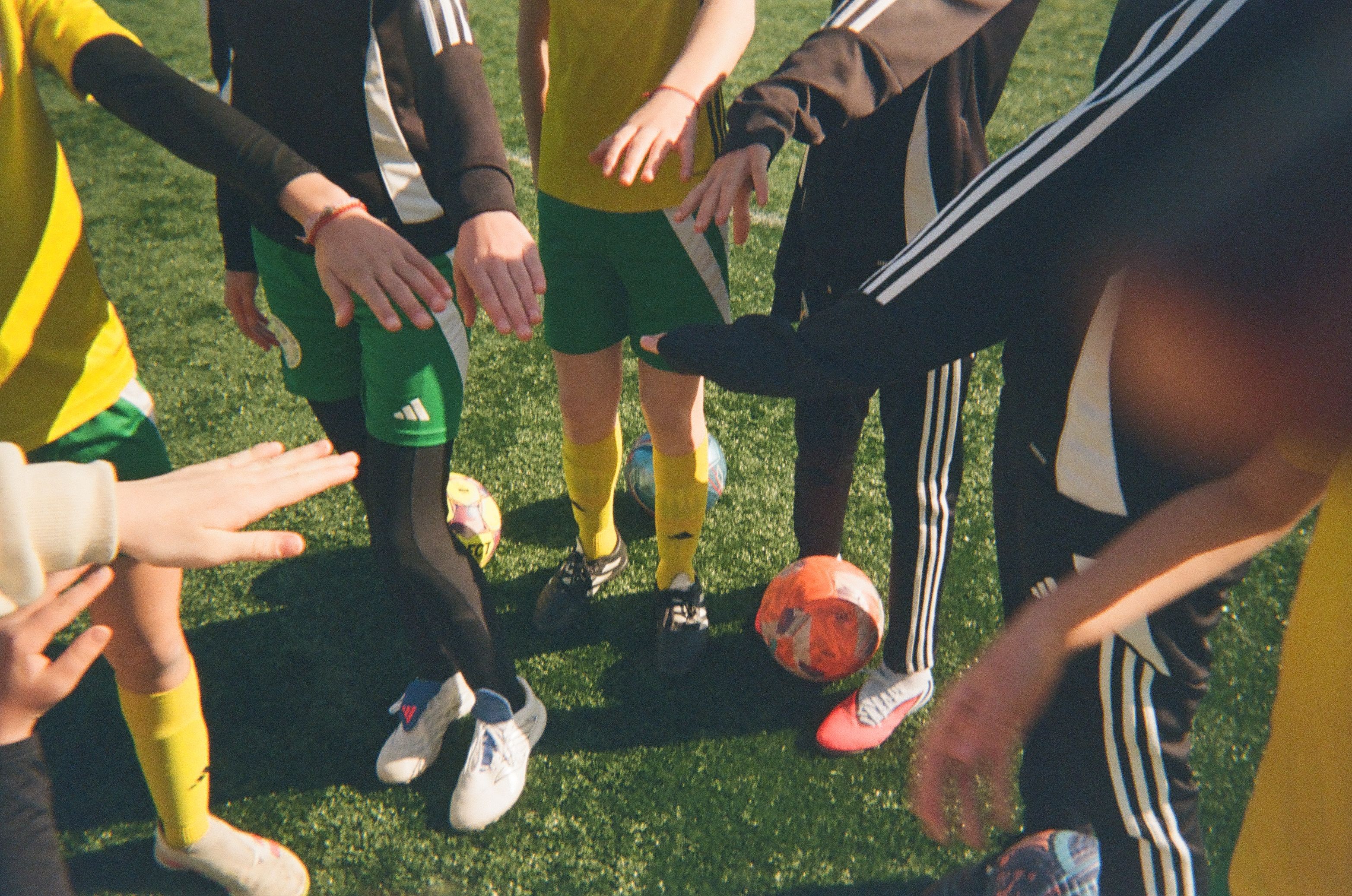 A group of girls standing in a circle, each with one hand in the middle.