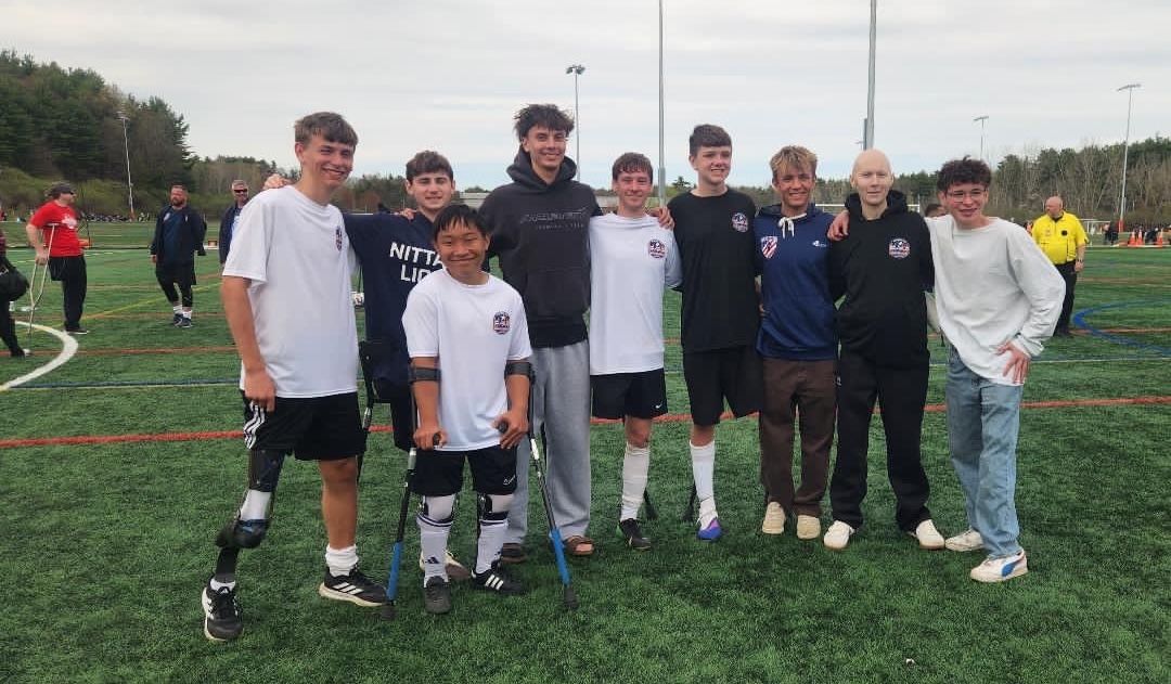 A group of amputee soccer players pose for a photo after soccer practice.