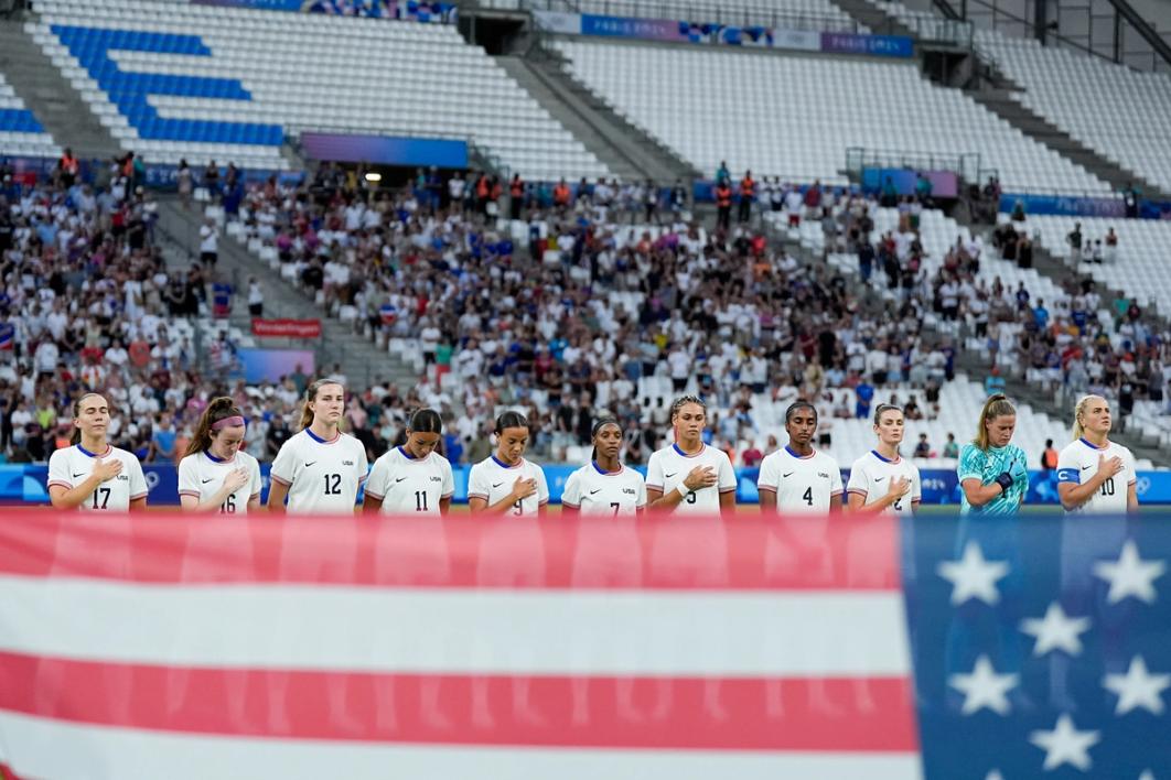 USWNT players during the national anthem prior to kickoff against Germany at 2024 Olympics.