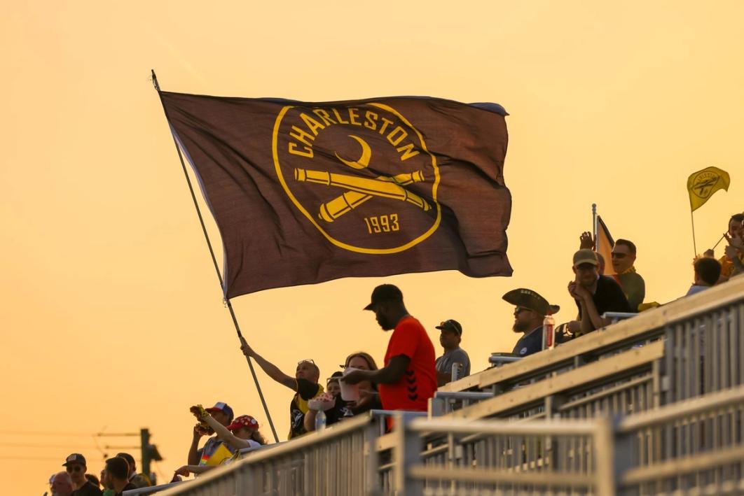 A Charleston Battery flag waving with a sunset in the background