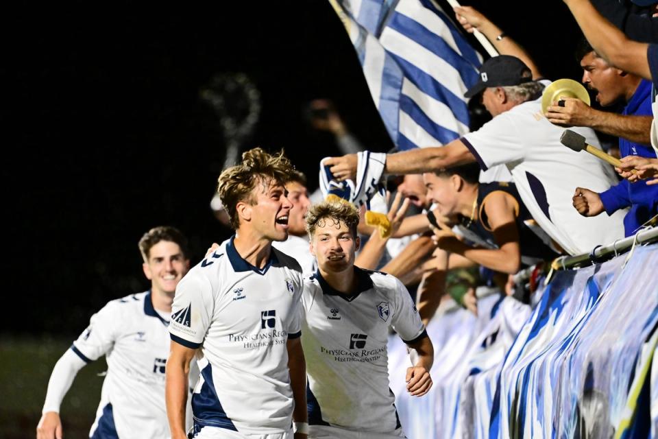Players celebrate with fans in the stands following an Open Cup match