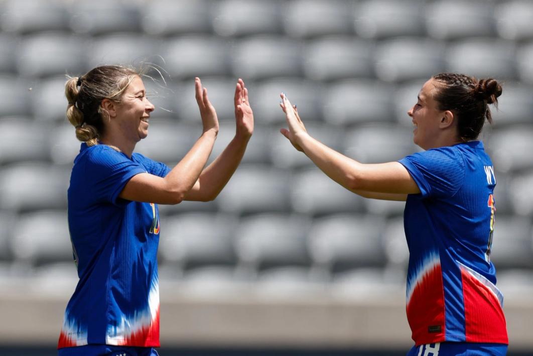Emily Spreeman and Faith Wylie celebrate and high five both wearing blue red and white kits during the deaf wnt match against australia