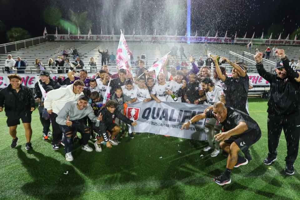 Soccer players celebrate and hold up a banner that says Qualified 2025 Lamar Hunt US Open Cup