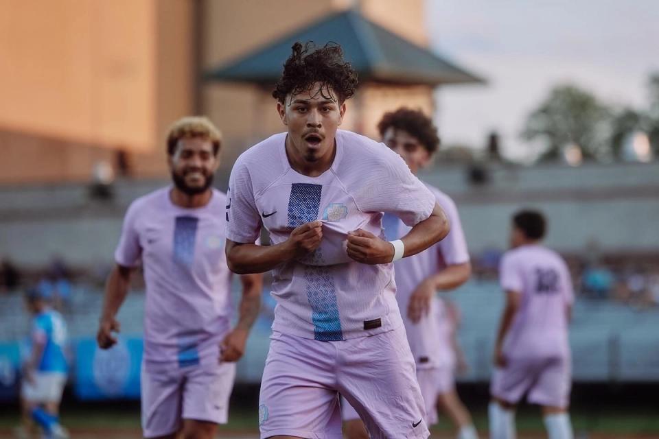 A Virginia Dream player shows off his badge to the camera