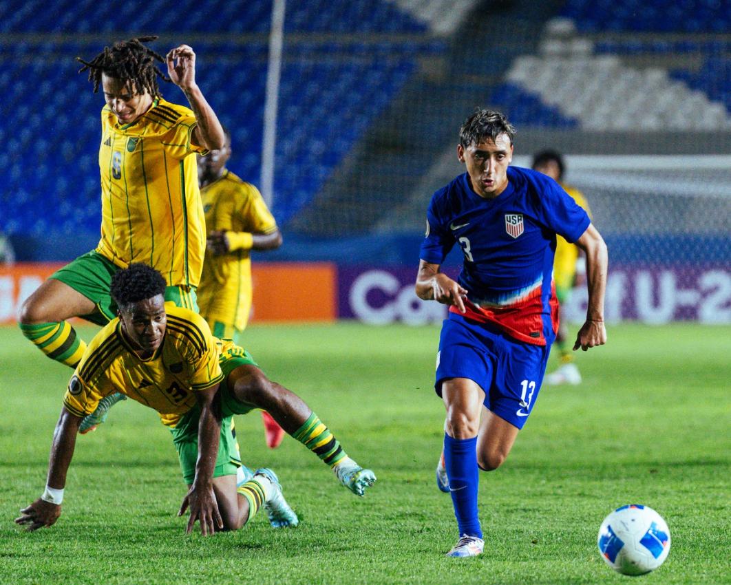 U-20 MYNT player dribbles past Jamaican defenders