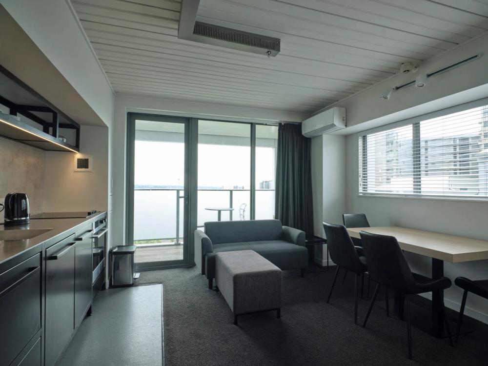 a living room with a couch , table , chairs and a balcony .