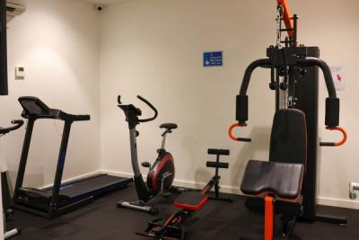 a gym with a treadmill , exercise bike , and weight machine .