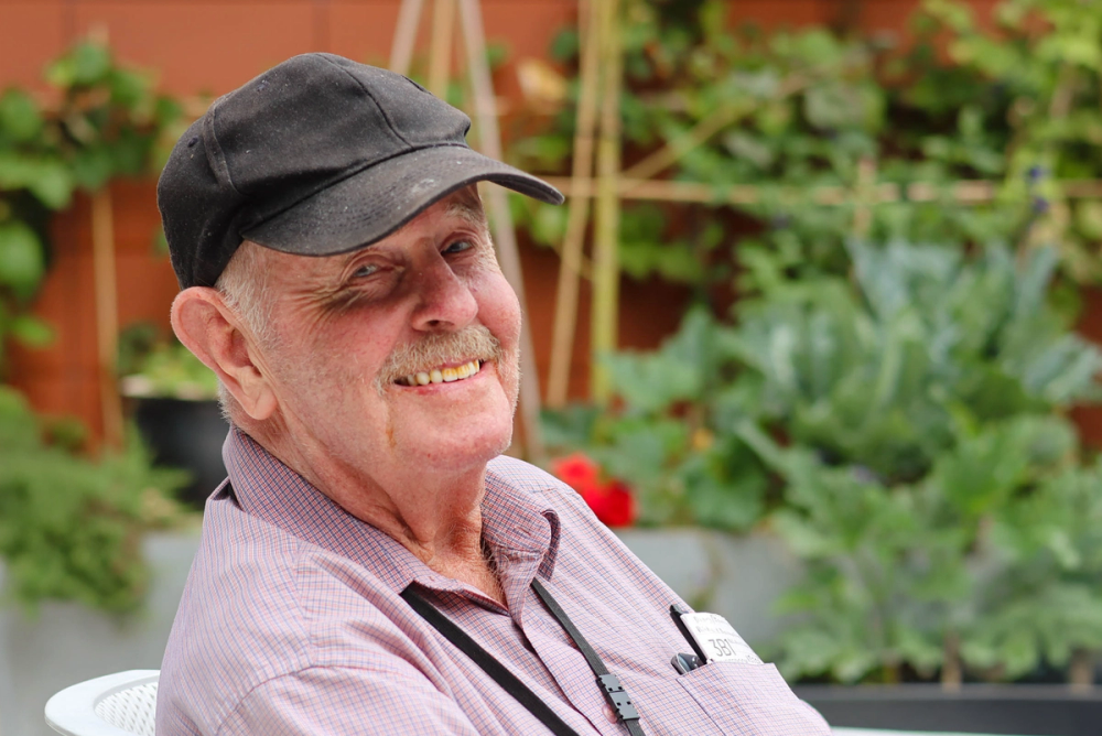 an elderly man wearing a hat and a name tag that says ' a ' on it