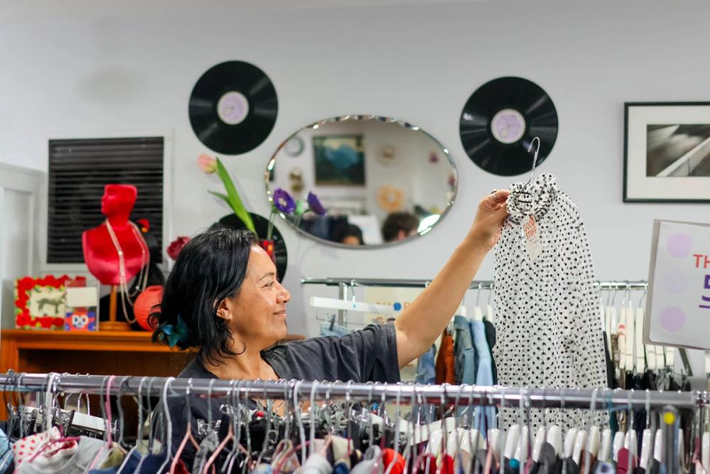 a row of jeans hanging on a rack in a store .