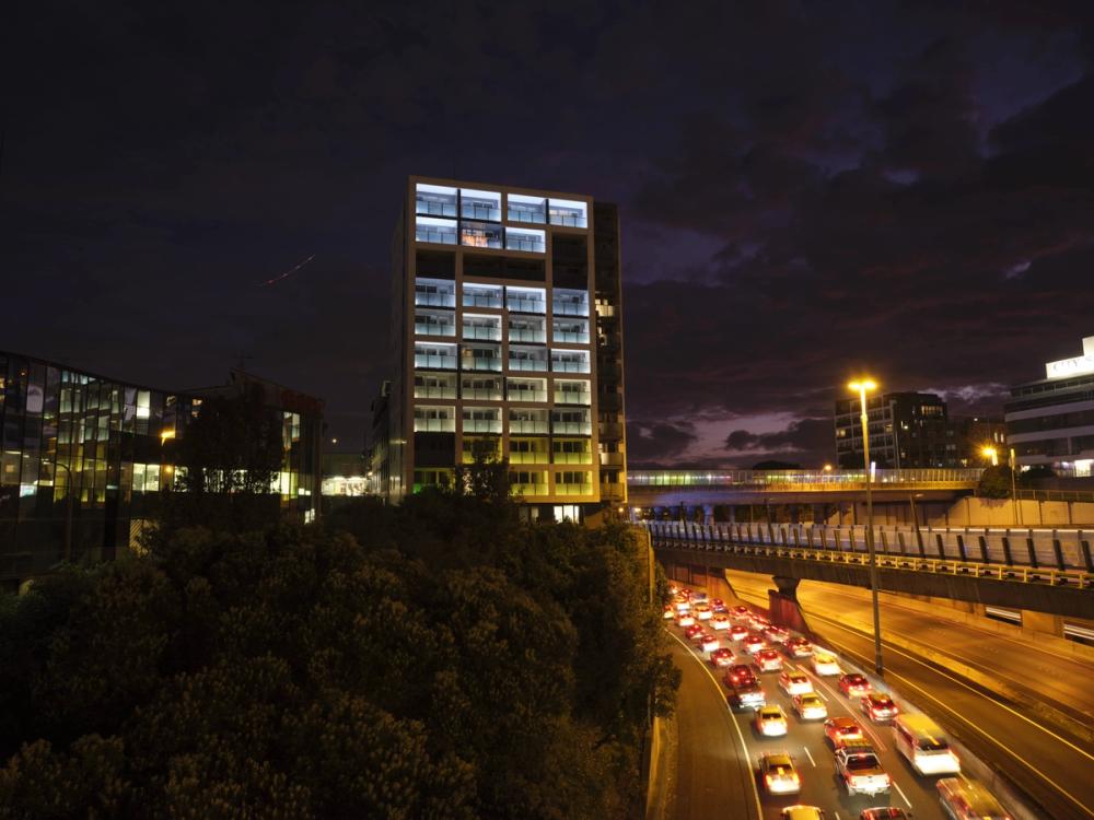 a busy highway at night with a building in the background .