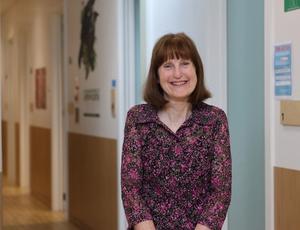 a woman is standing in a hallway smiling at the camera .