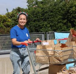 a woman is pushing a shopping cart filled with bags .