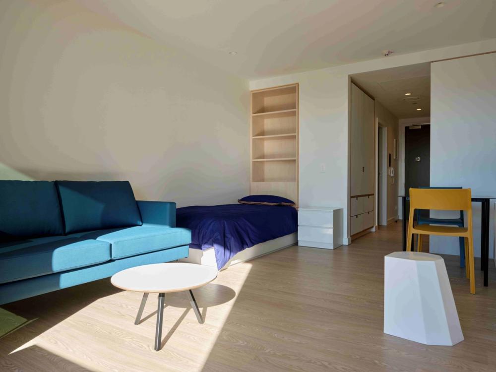 a group of people are sitting at a table talking to each other .