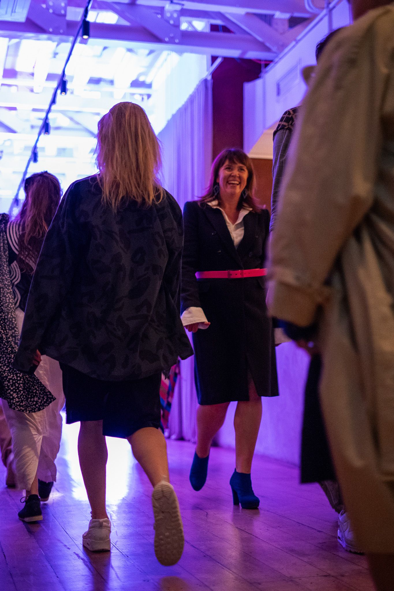 a woman wearing glasses and a necklace is smiling in front of a white house .