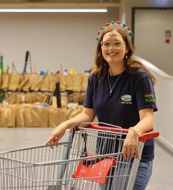 a woman is pushing a shopping cart filled with bags .