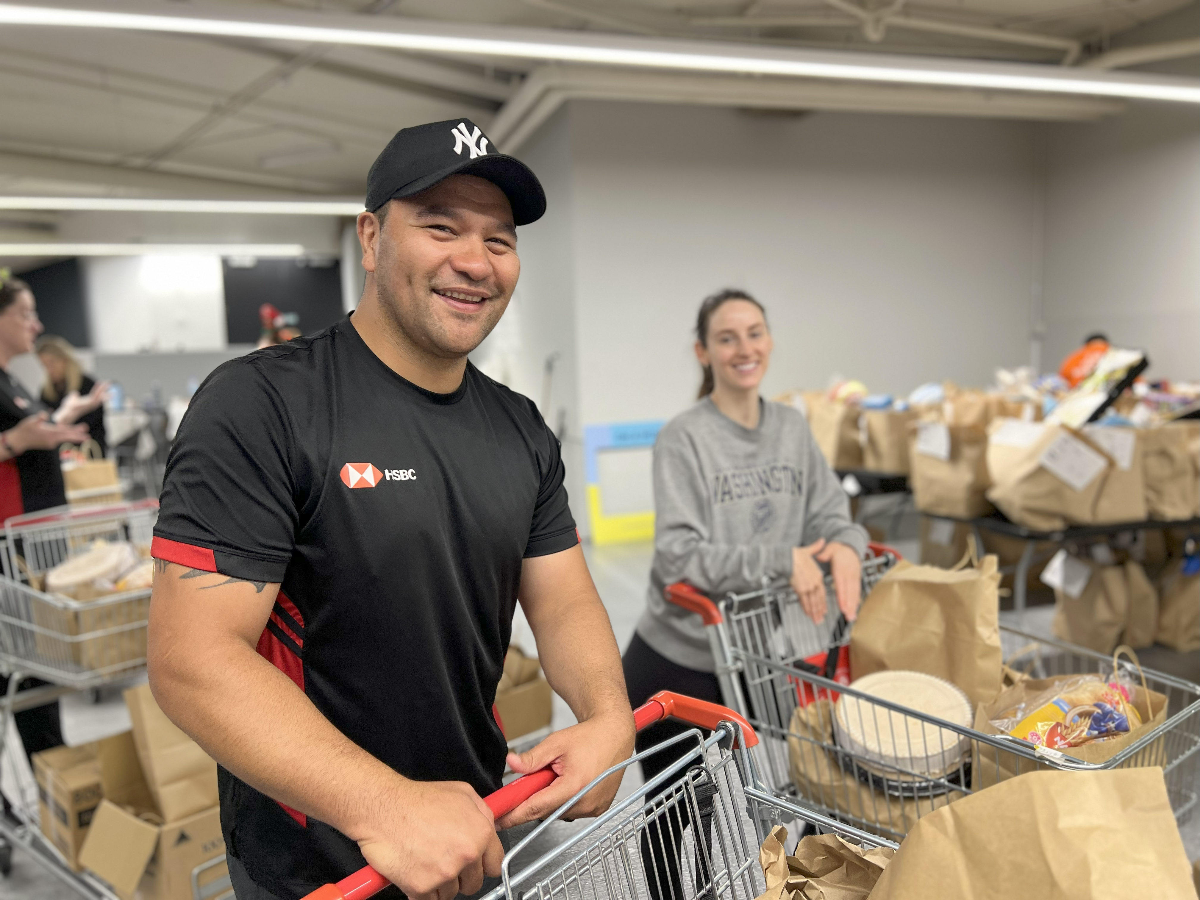 a man in a black shirt smiles while holding onto a trolley