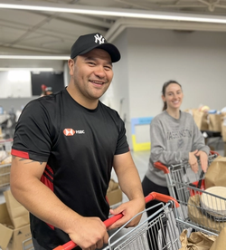 a man in a black shirt smiles while holding onto a trolley