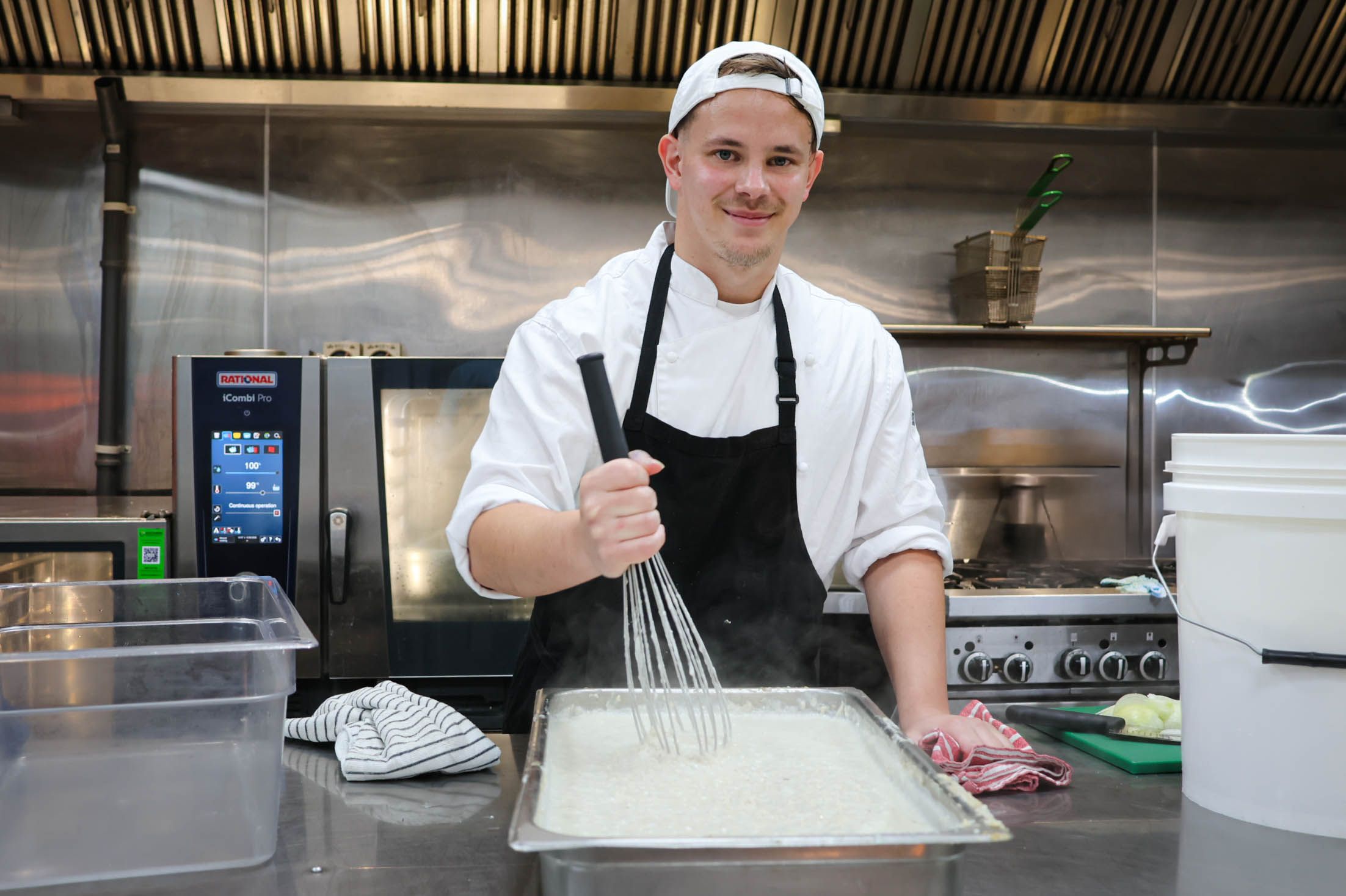 a woman wearing glasses and a necklace is standing in front of a white house .