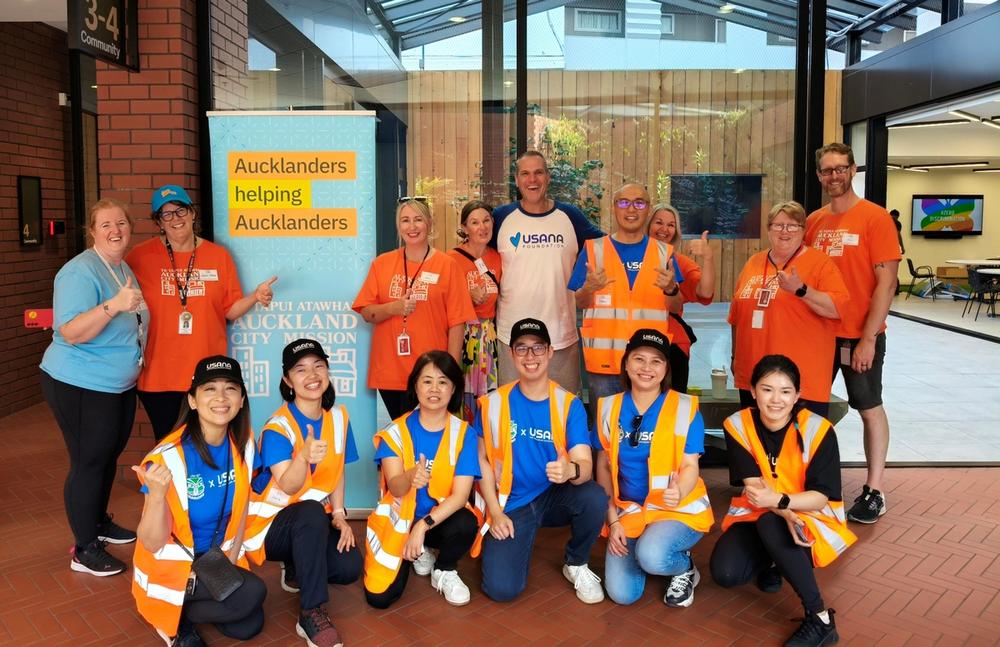 a woman in an apron holds a bottle of oat milk