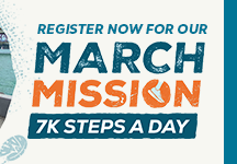 a woman smiling at the camera holding a box of donated food