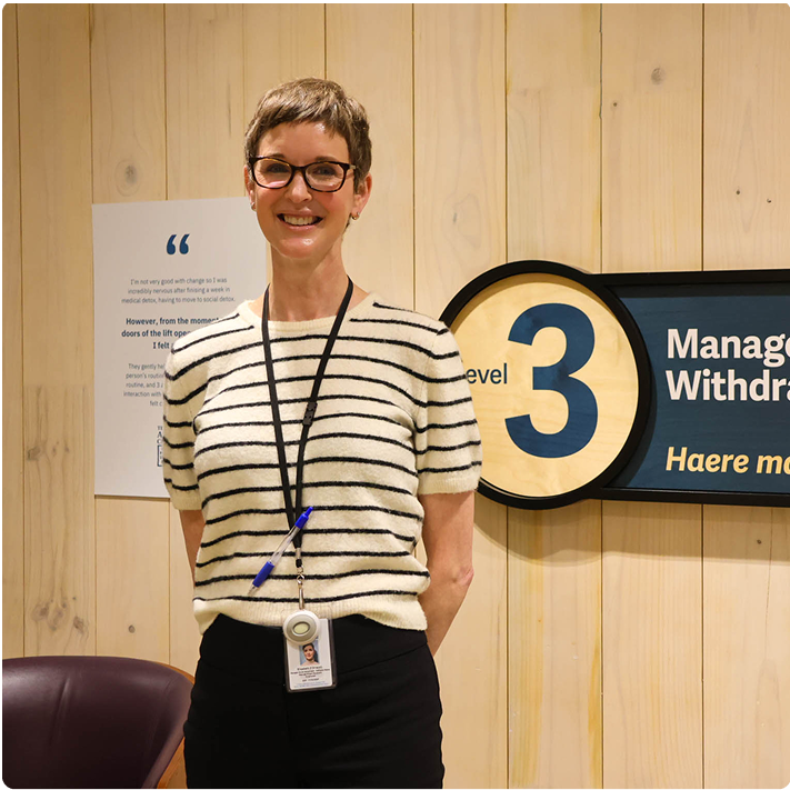 a woman stands in front of a sign that says manage withdraw