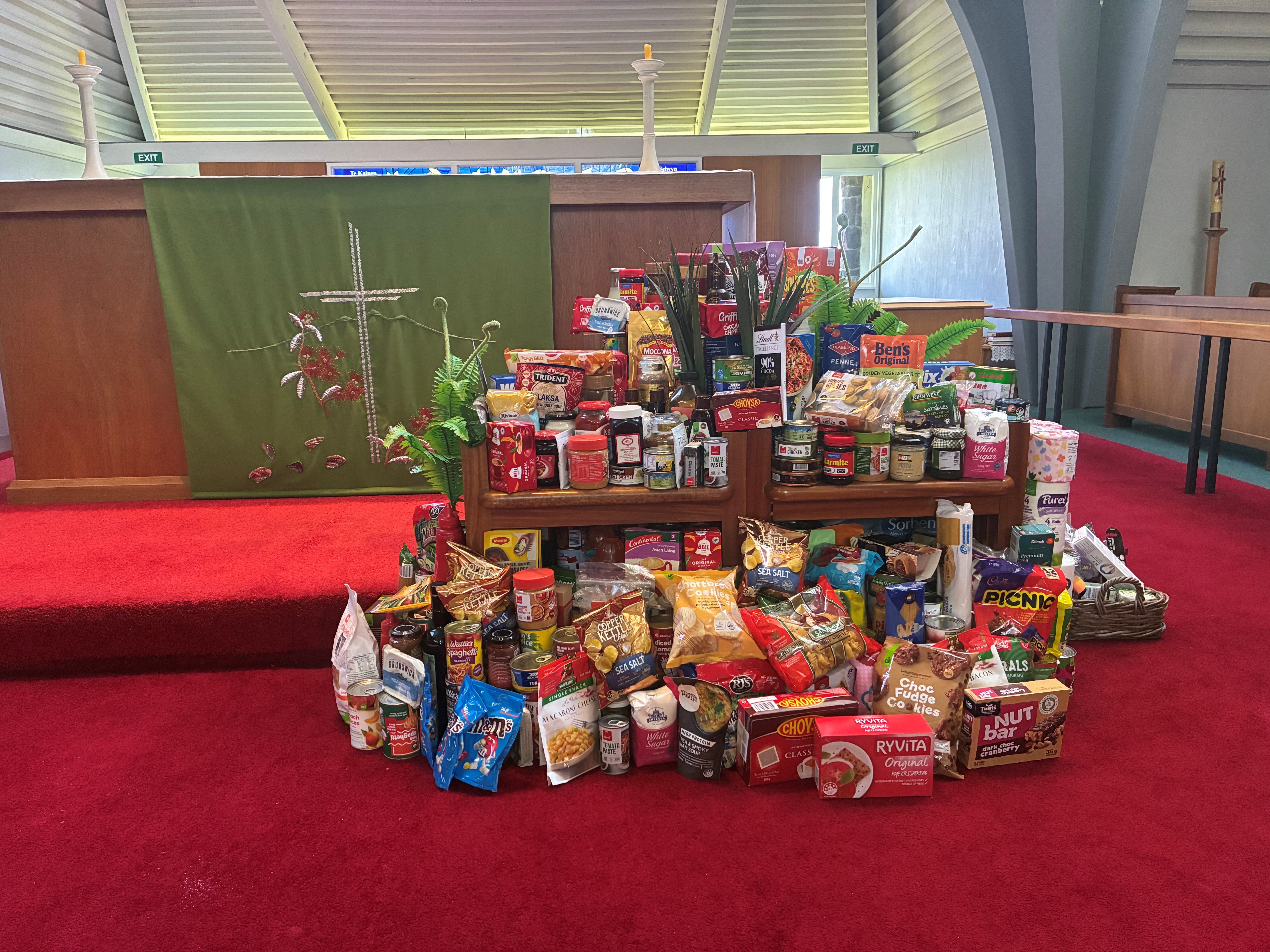 a woman in a pink vest is holding a box full of food