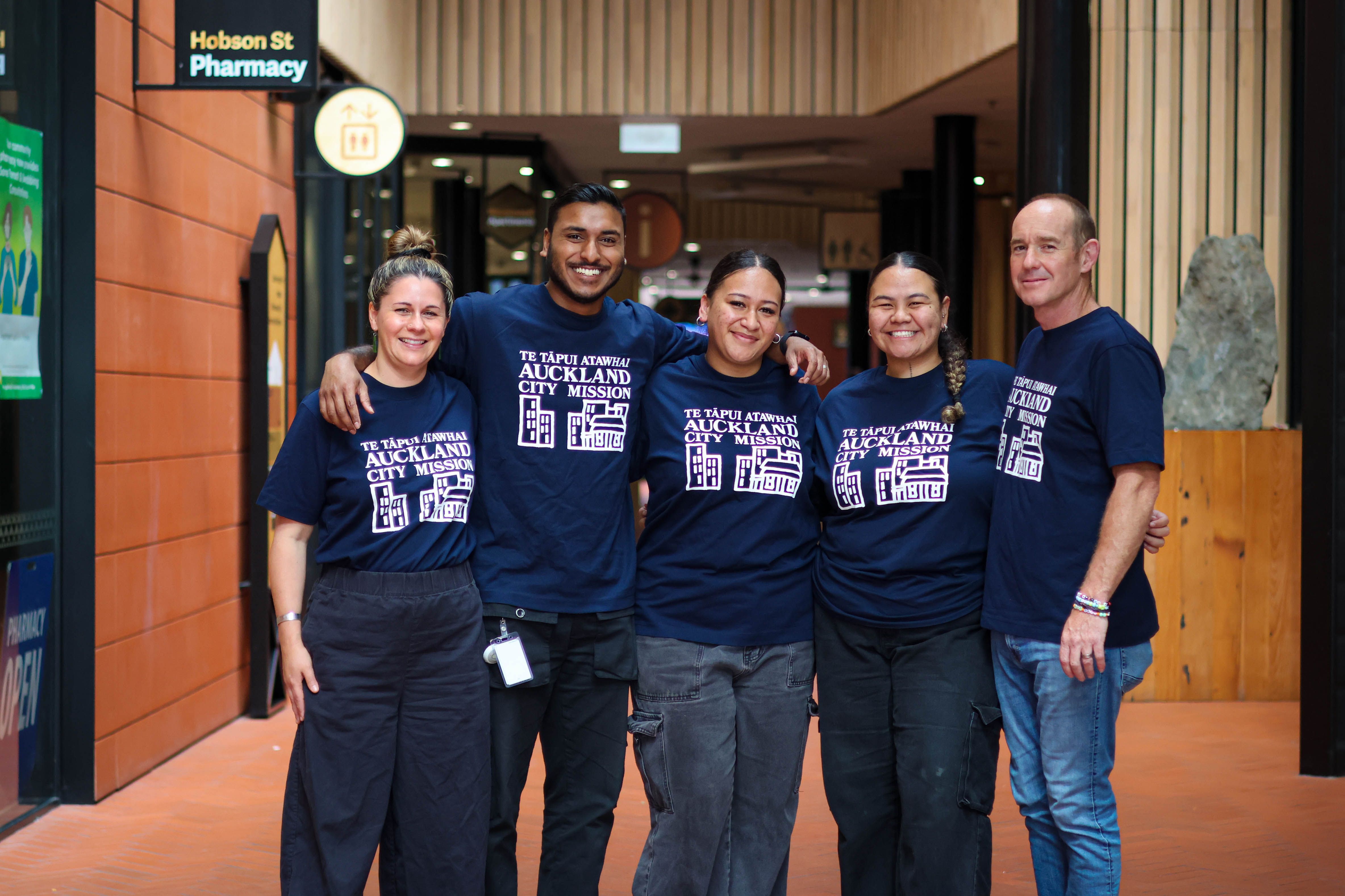 a group of people are posing for a picture in front of a building .