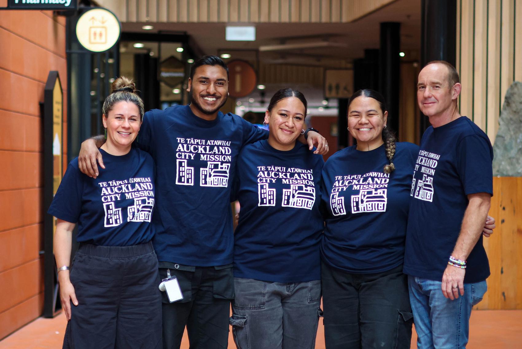 a group of people are posing for a picture in front of a building .