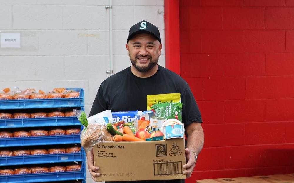 a man is holding a box full of food
