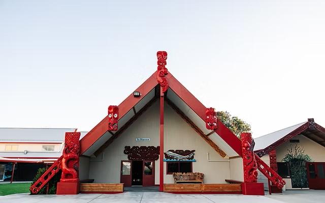 a large red and white building with a blue sky in the background .