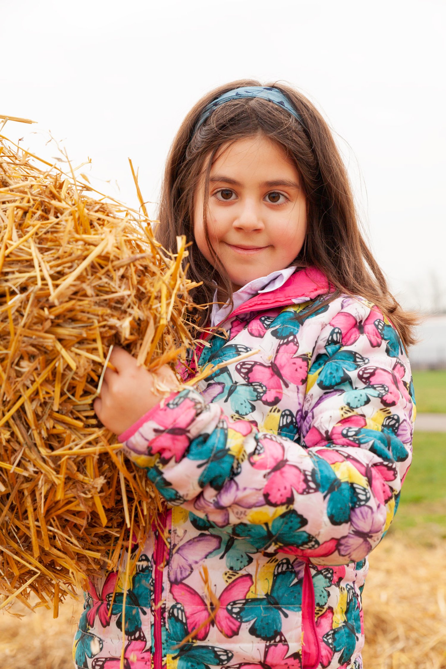 a girl holds hay and smiles