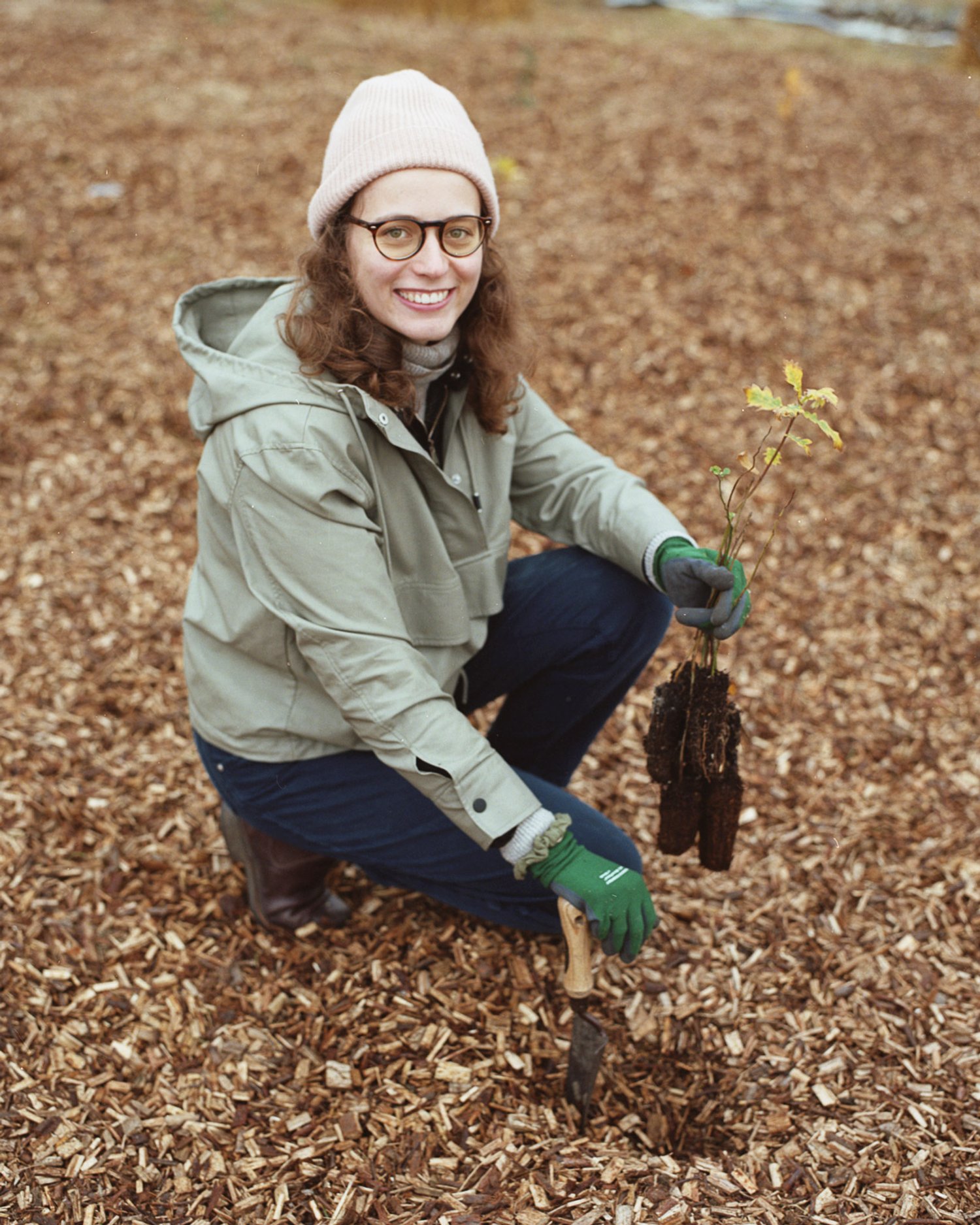 a woman plants a tree sapling