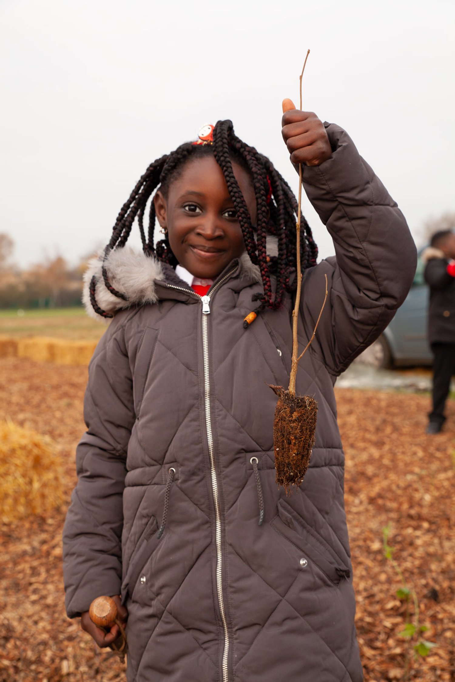 a girl holds a tree sapling