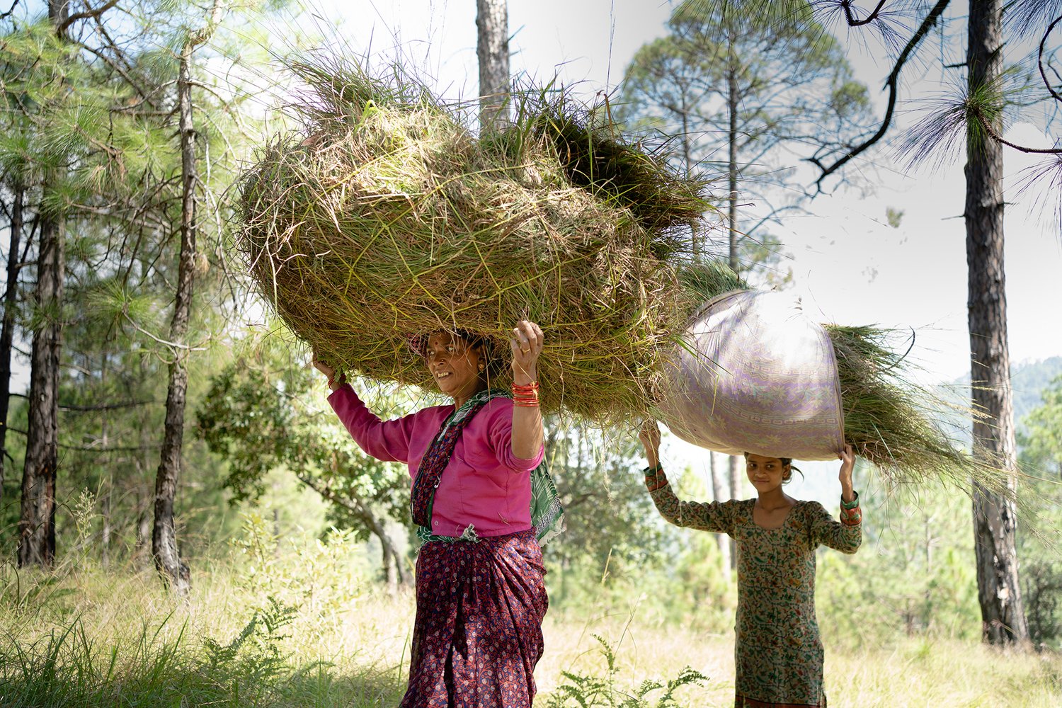 women carry bags of husk on their heads