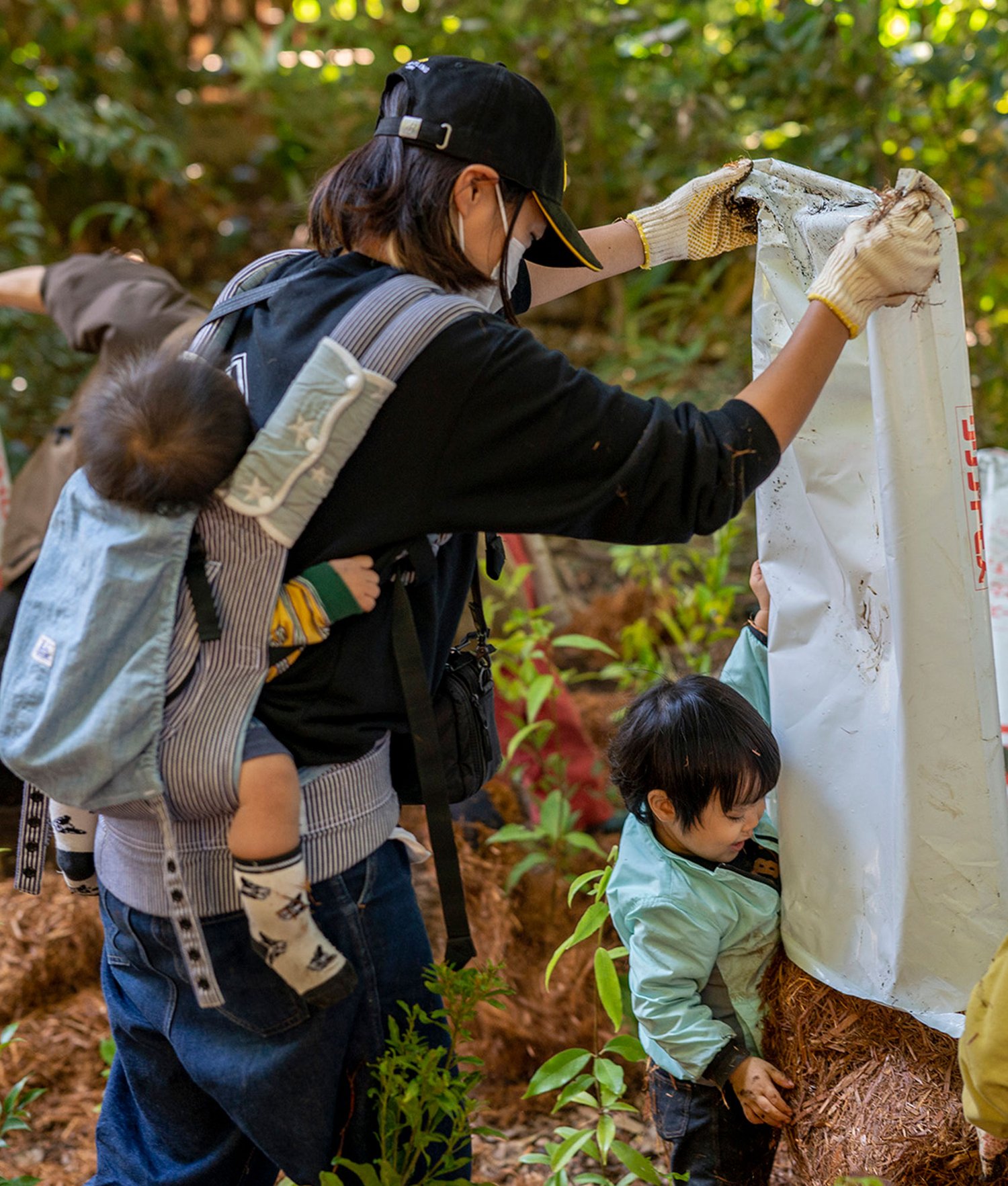 children wait with their families to plant a forest
