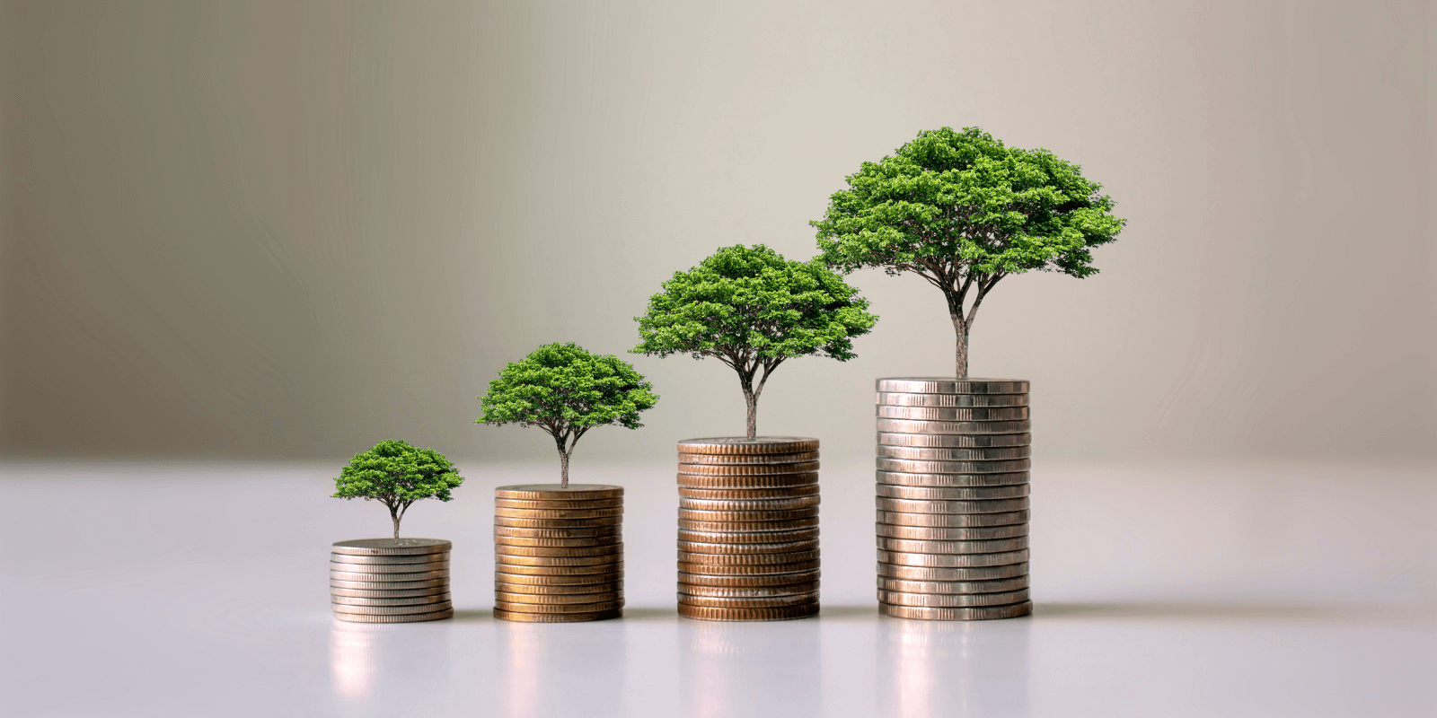 Montones de monedas con un árbol en cada una de ellas, representando la financiación para startups cleantech
